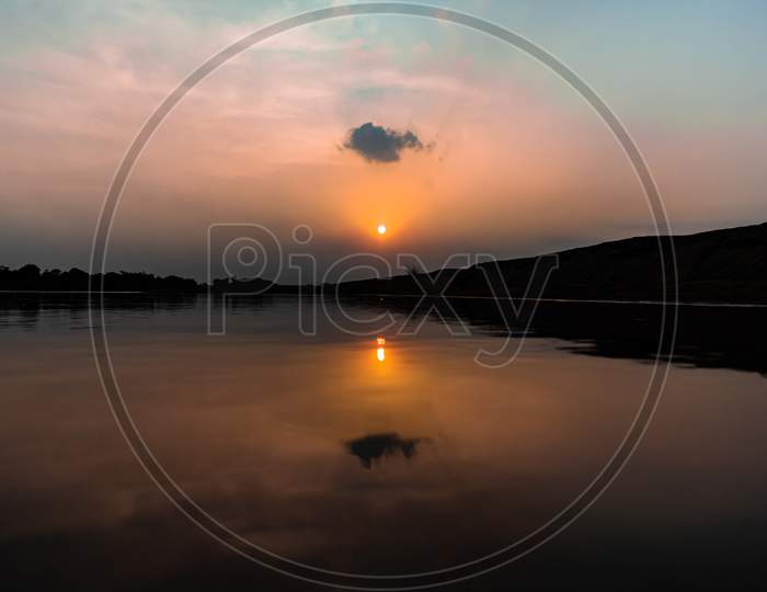 SUNSET WITH ITS REFLECTION ON RIVER WATER SURFACE