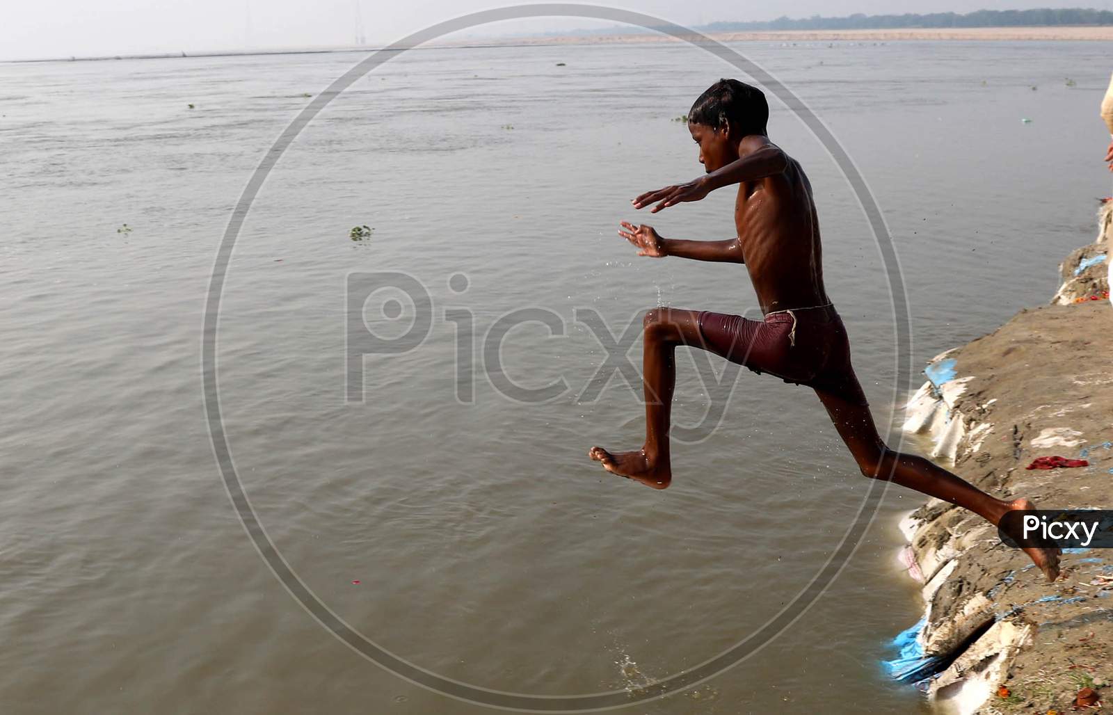 A Boy Jumps In The River Ganga To Beat The Heat On A Hot Day In Prayagraj, June 10, 2020.