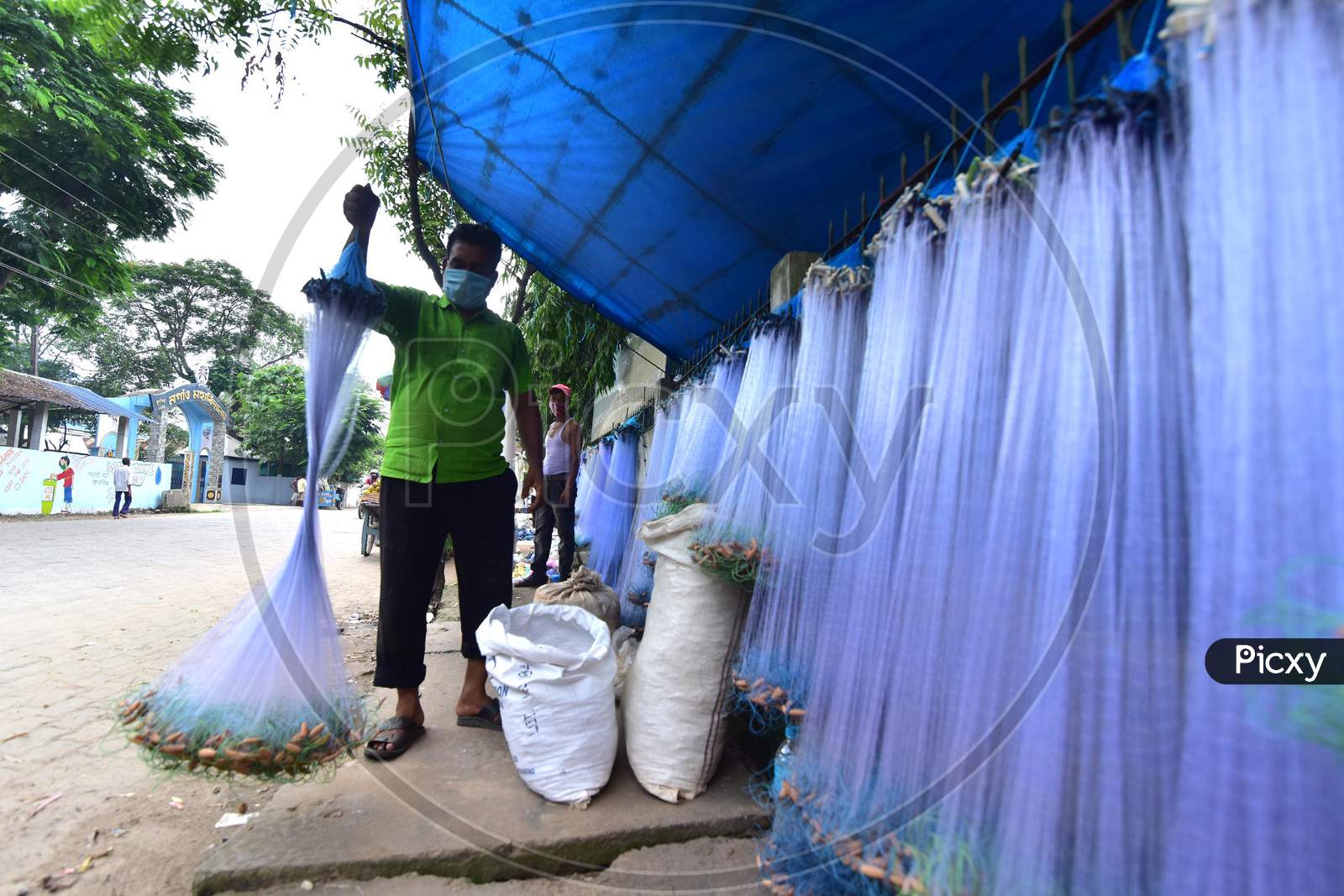 Image of A Vendor Arranges Fishing Net On His Roadside Shop For