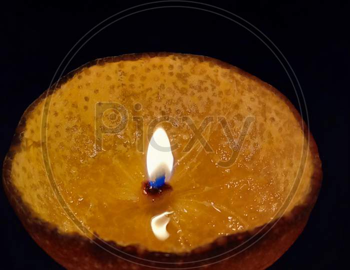 Orange peel candle fire dark background