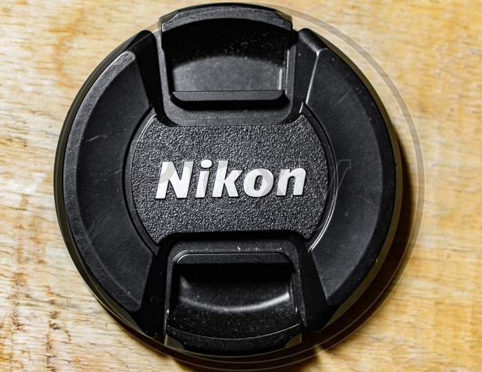 NIKON 18-55 mm LENS CAP ON WOODEN TABLE