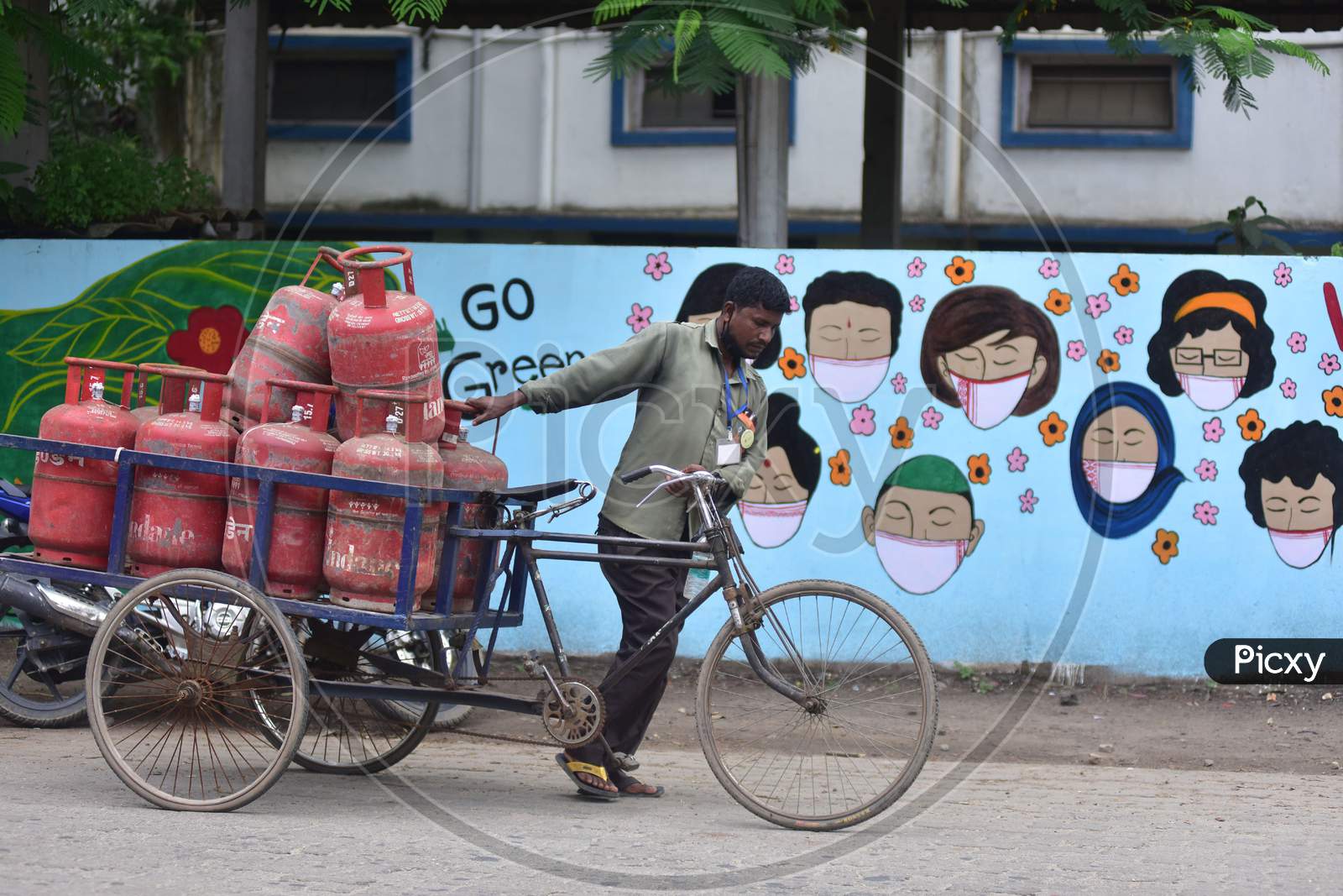 A Worker  Pushes  A Cart With Lpg Cylinders  In Front Of Wall Graffiti During Ongoing Covid19 Lockdown In Nagaon District In The Northeastern State Of Assam, India On June 9,2020