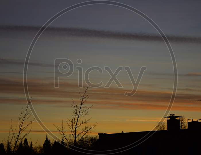 Silhouette Of Building With Yellowish Orange Twilight Sky In The Background