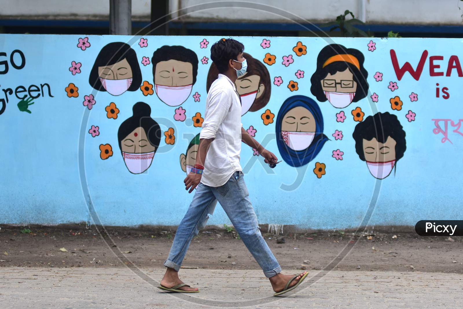 A Man Walks In Front Of Wall Graffiti During Ongoing Covid19 Lockdown In Nagaon District In The Northeastern State Of Assam On June 9,2020.