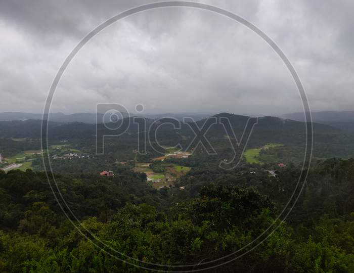 A Landscape View Of Green Hills With Cloudy Sky On The Background In Coorg, India.