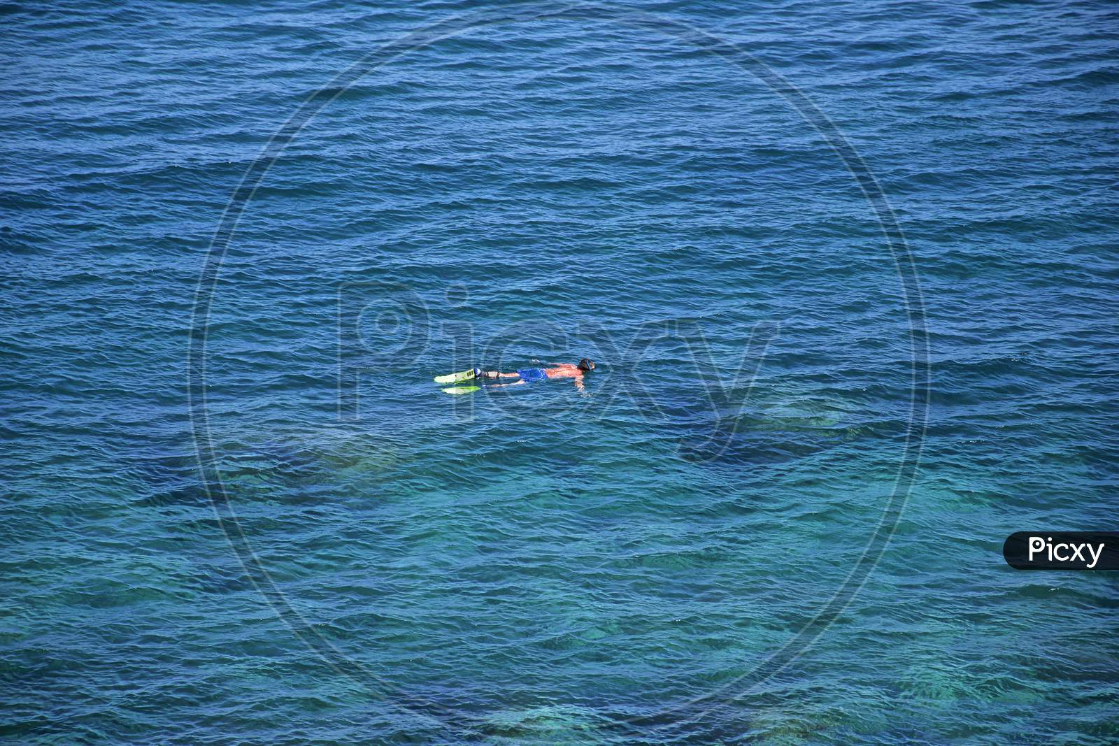 Man Floating On Blue Ocean Water Near Catania, Sicily