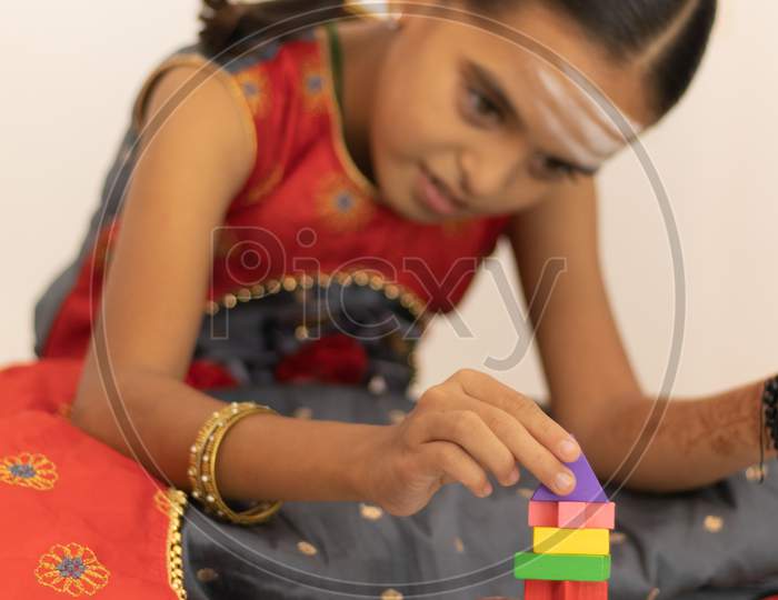 Focus On Hands Of Cute Little Child Girl Playing With Colorful Wooden Blocks In The Room