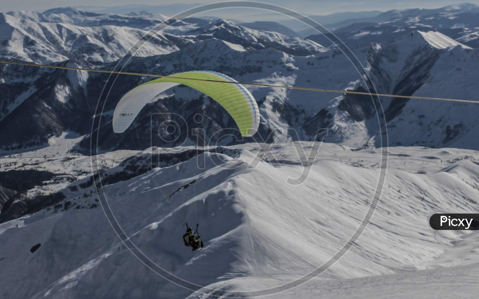 Gudauri, Georgia- February 2019: Ski Resort Paragliding Flying Down Mountain