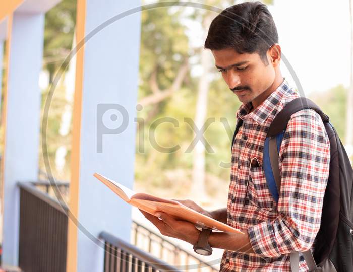 A Student studying by Looking Into Books At College - Education, Learning Student, People Concept