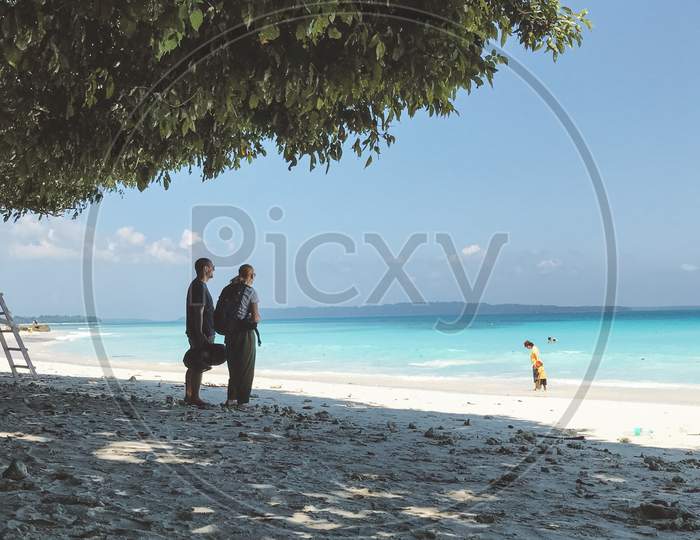 Couple looking at the ocean from the shore in andamans