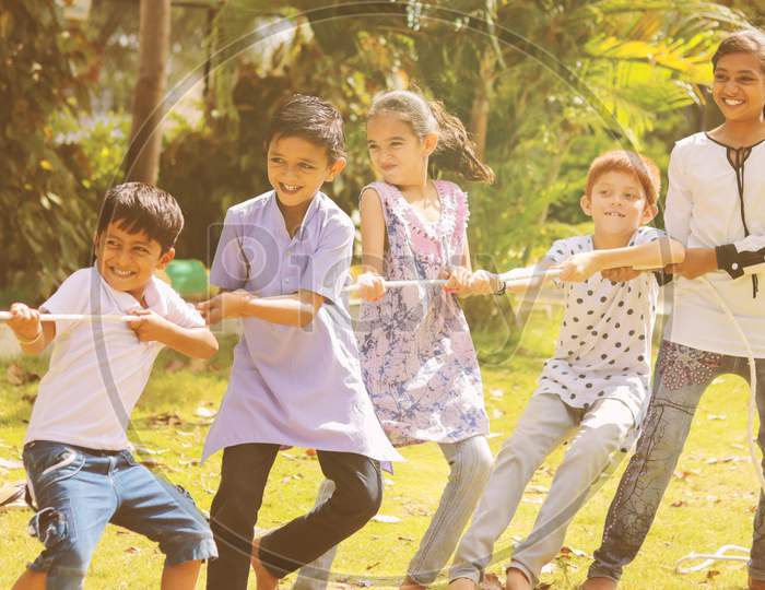 Group Of Multi Racial Children Playing Tug Of War Game Kindergarten - Multi Ethnic Kids Playing Outdoor Games Against Racism.