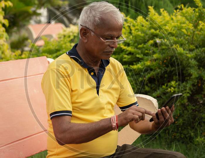 Elderly Man Or Old Man using a mobile At Outdoors