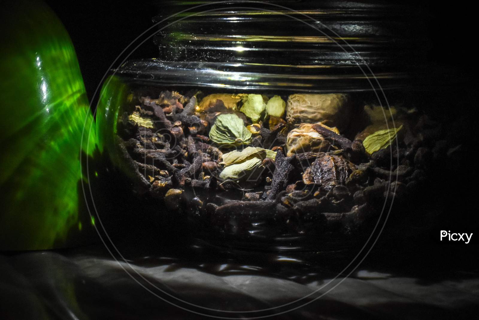Some ingredients like cloves, cardamom and nutmeg in the glass pot