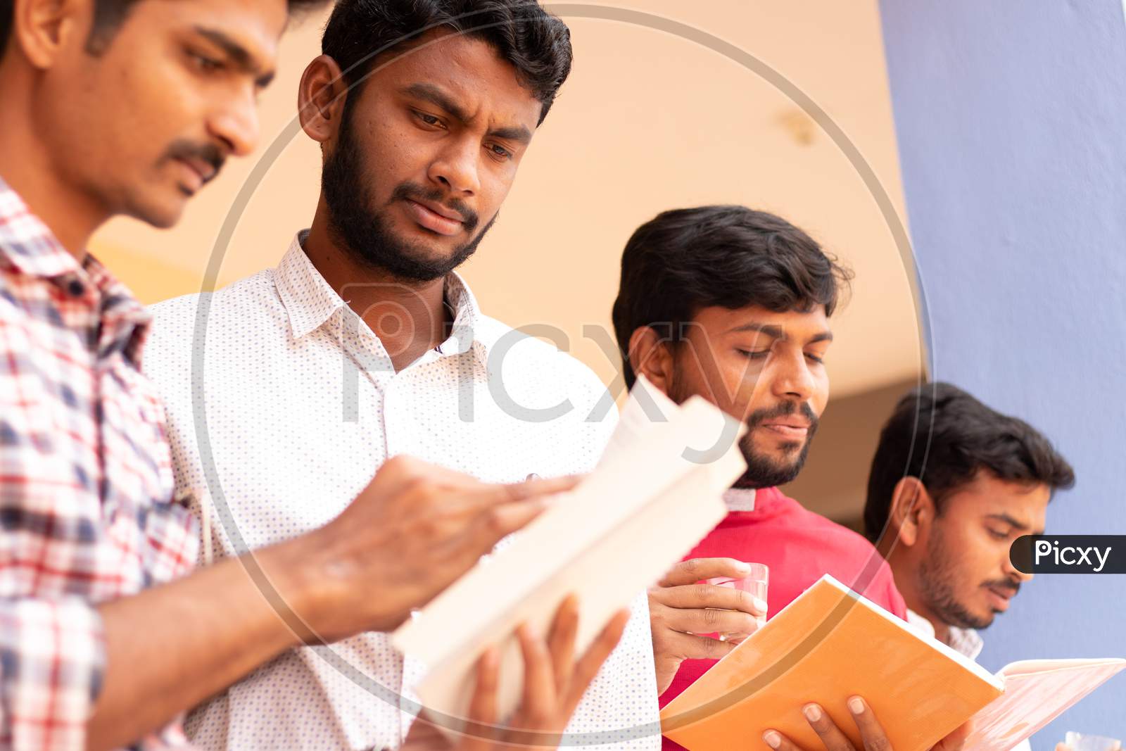 Group Of Students studying together and clearing doubts by Looking Into Books At College - Education, Learning Student, People Concept