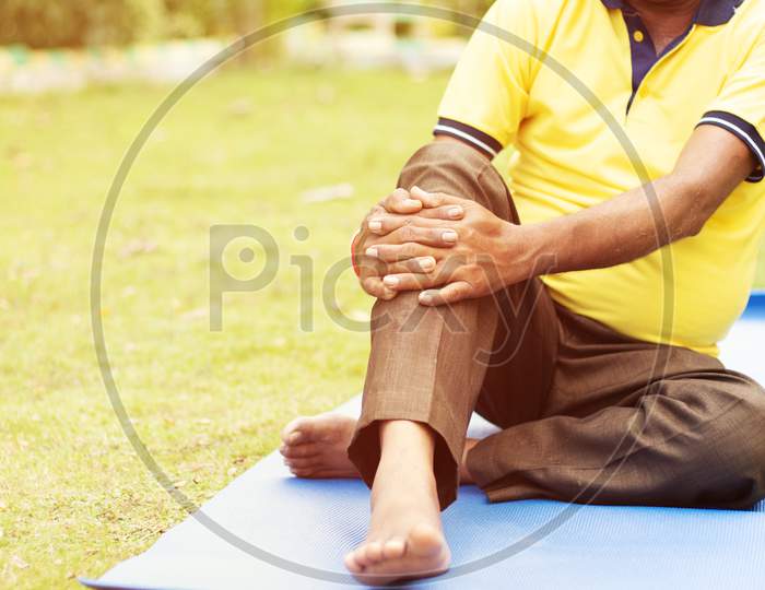 Elderly Man or Old Man Holding Knee Due To Pain, Senior Man Fitness And Yoga At Outdoor