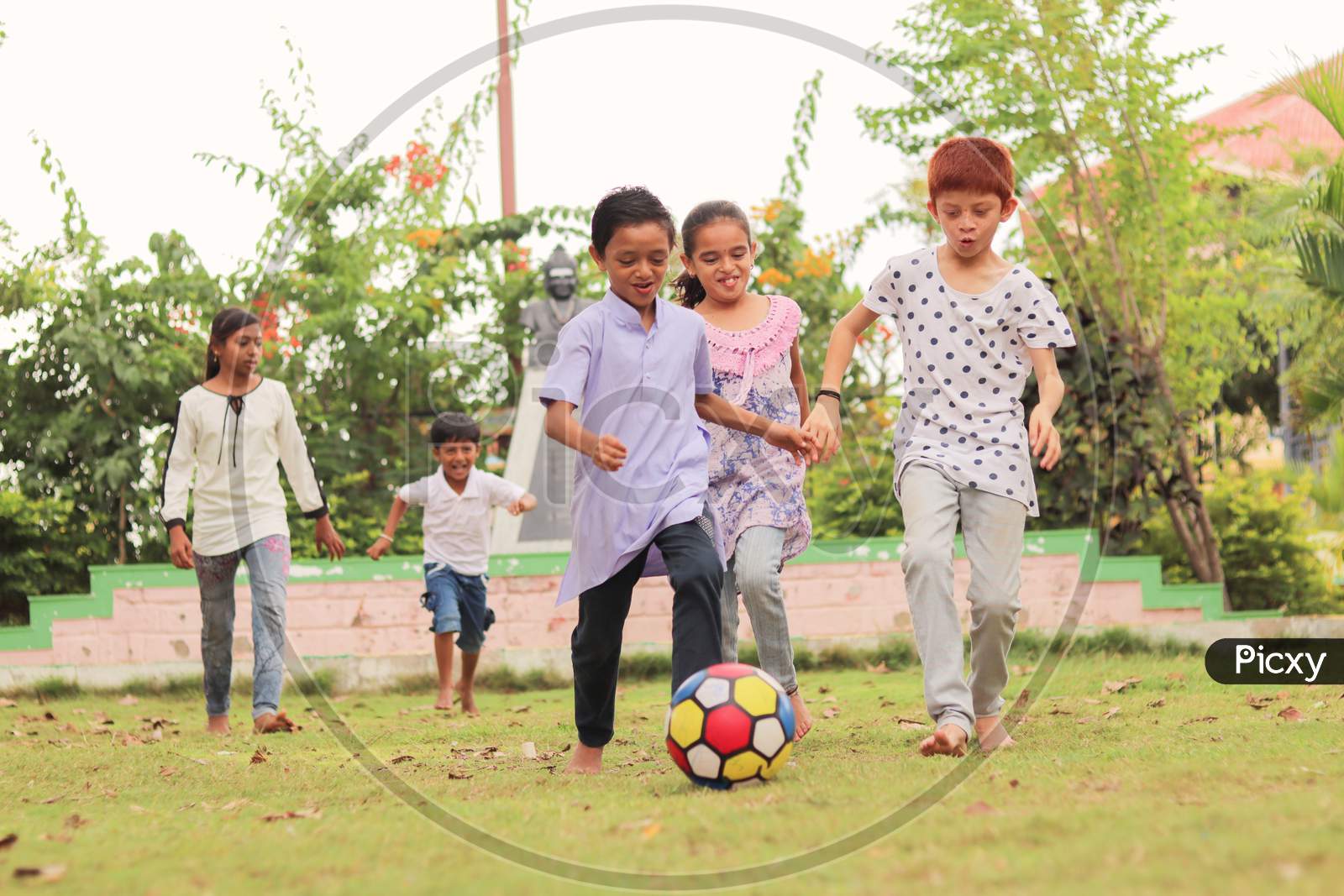 Children Playing Football Outdoor Game - Concept Of Kids Enjoying Outdoor Games In Technology-Driven World.