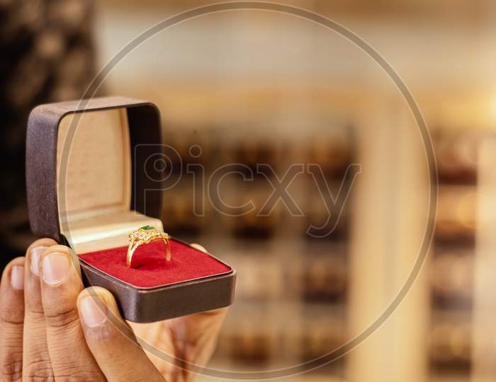 Close Up, Hands Showing Gold Ring At Jewelry Box With Copy Space At Jewellery Store.