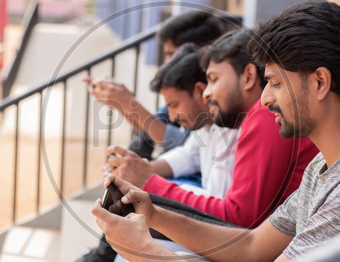 Group of Students using mobile phones or Smartphones At College - Education, Learning Student, People Concept