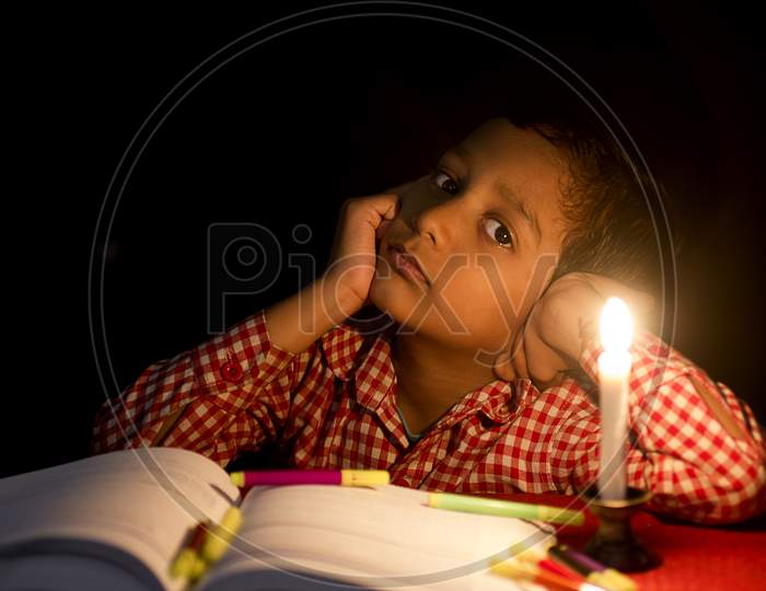 Portrait of a Kid with Books and Candle in the foreground