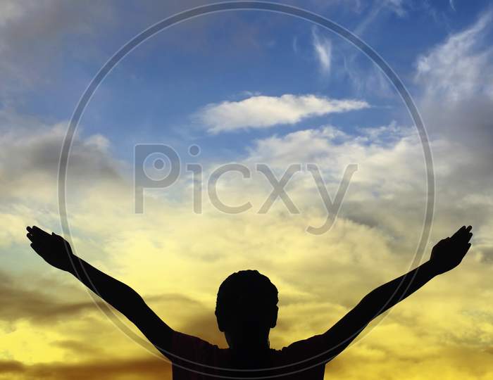 Silhouette of a Person with Hands Raised