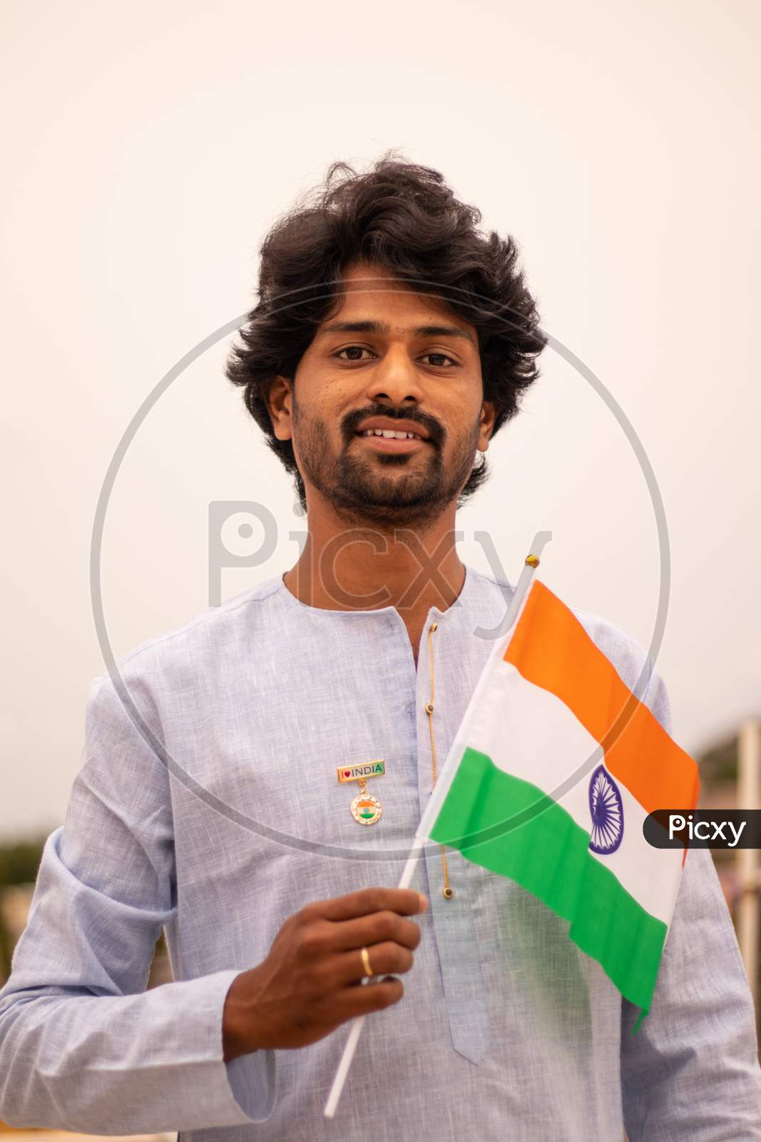 Portrait Of A Young Indian Man Holding Indian Flag In Traditional Indian Dress.