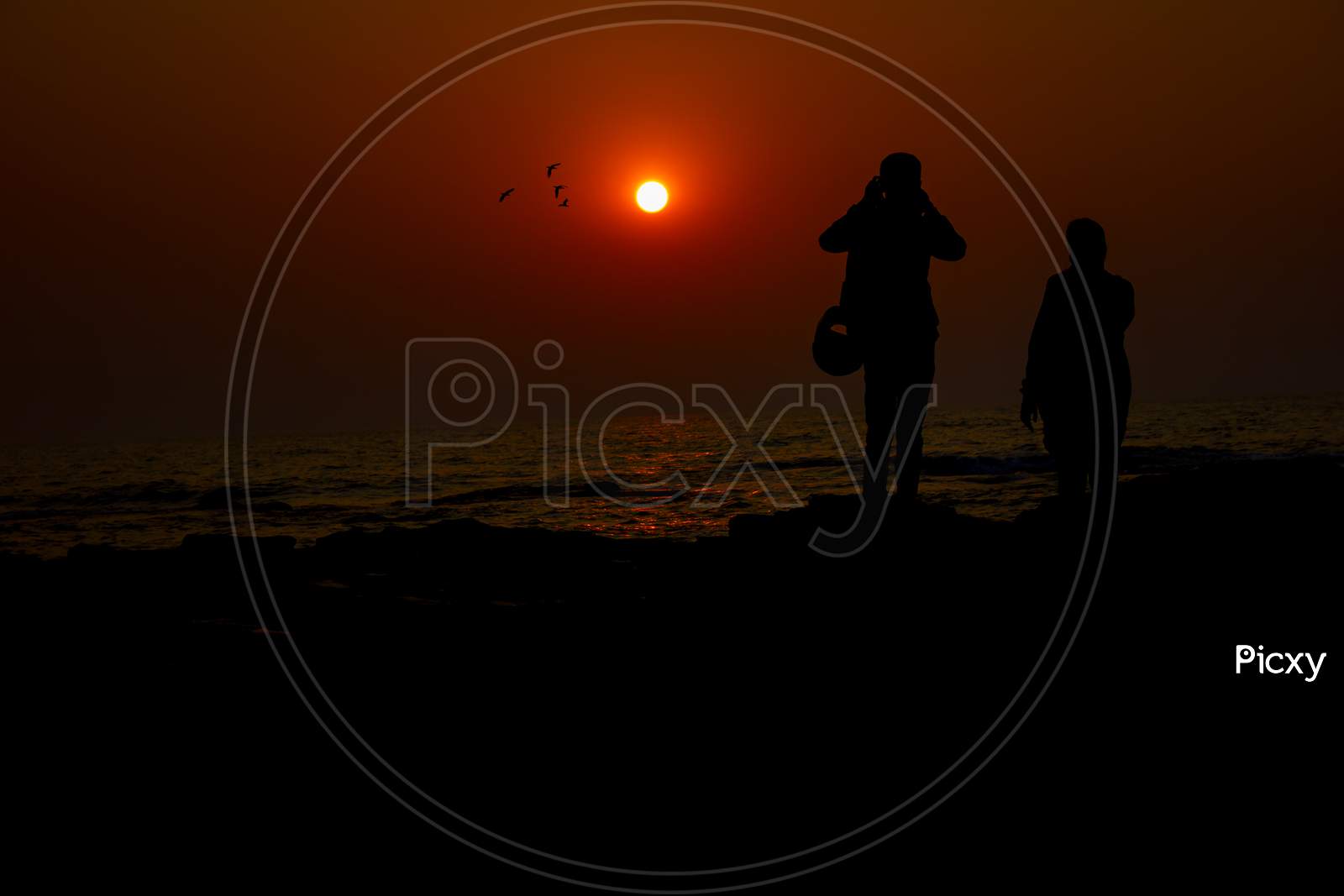 Silhouette of People with Sunset in the Background