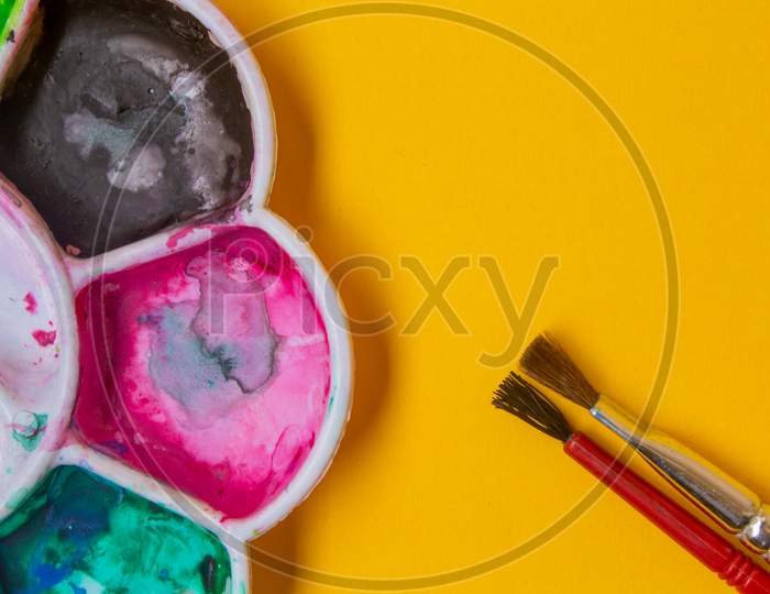 View Of Paint Palette With Different Colors And Paint Brushes. Selective Focus.