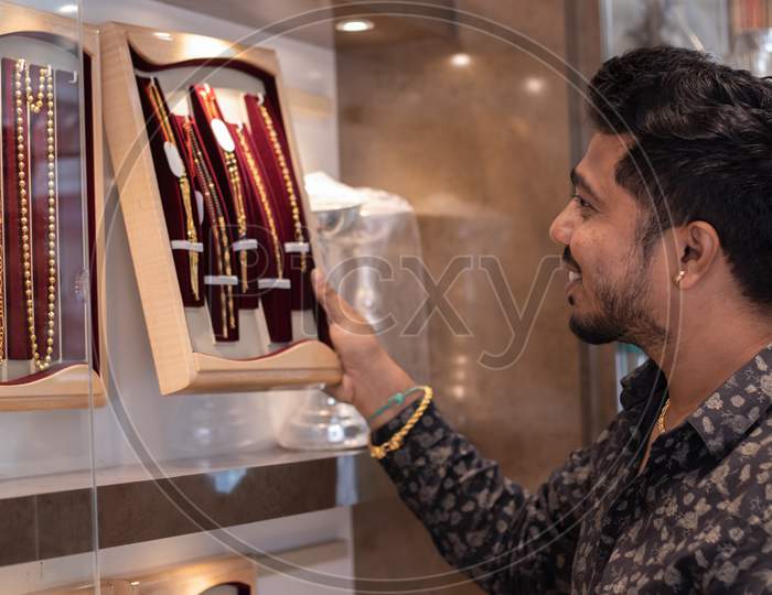 A Person Viewing A Gold Chain At Jewelry Box With Copy Space At Jewellery Store