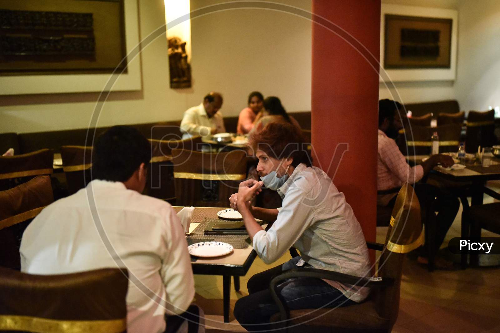 People sit in a restaurant after the authorities allowed to reopen the eateries, during the fifth phase of coronavirus lockdown in Vijayawada.