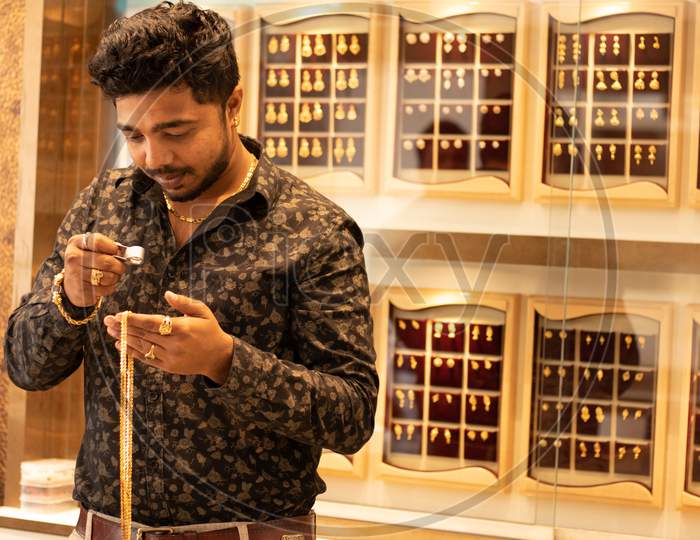 A Young Man viewing Gold items in a Jewellery Shop