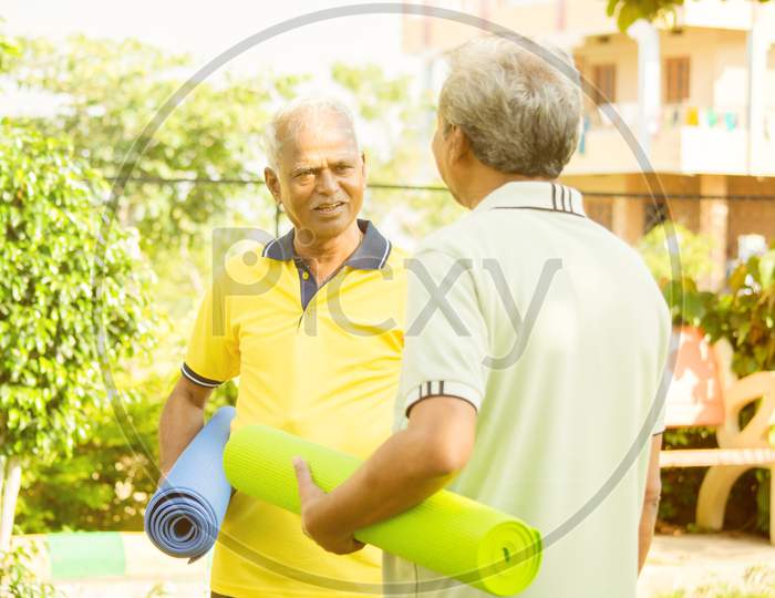 A couple of Old or Elderly Men's Talking to Each Other with Yoga Matt in Hands