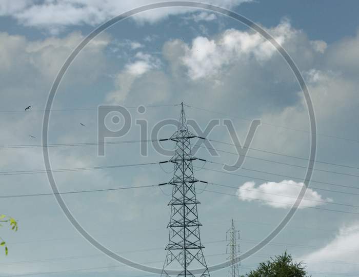 An Electric Tower with Clouds in the Background