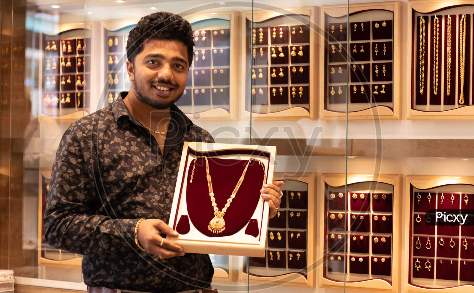 A Happy Young Person Holding A Gold Chain At Jewelry Box With Copy Space At Jewellery Store