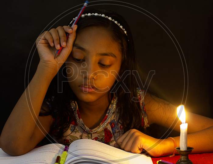 Portrait of a Young Indian School Kid with A Book and Candle in the foreground