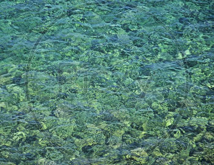 Turquoise Colored Rocks Visible Through Clean And Transparent Sea Water