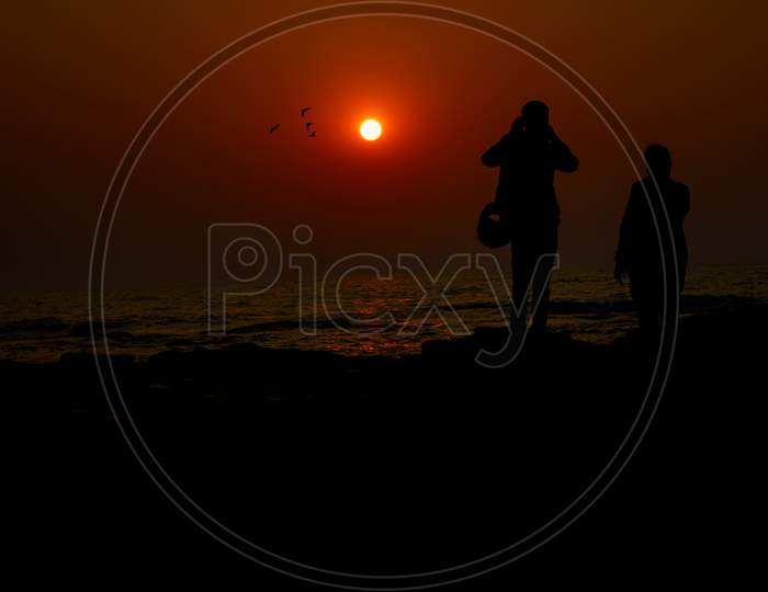 Silhouette of People with Sunset in the Background