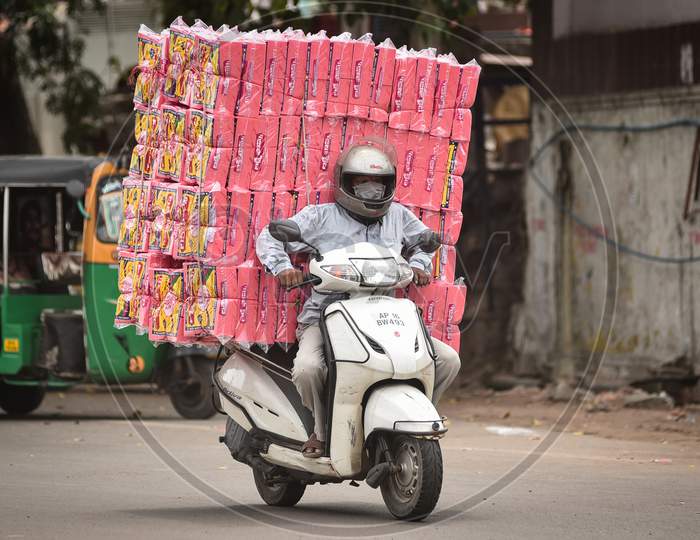 A man carries a pile of foam material, during the fifth phase of coronavirus lockdown in Vijayawada.