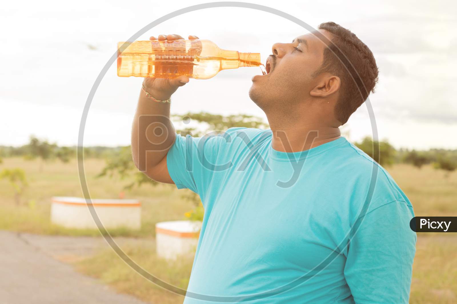 A Tired Man Drinking water after A Running Activity or Fitness Activity