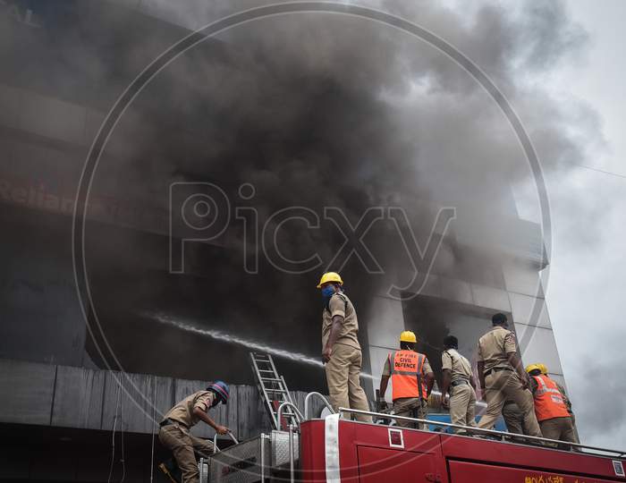 Firefighters douse a fire that broke out at a Reliance Trends store, during the fifth phase of coronavirus lockdown in Vijayawada.