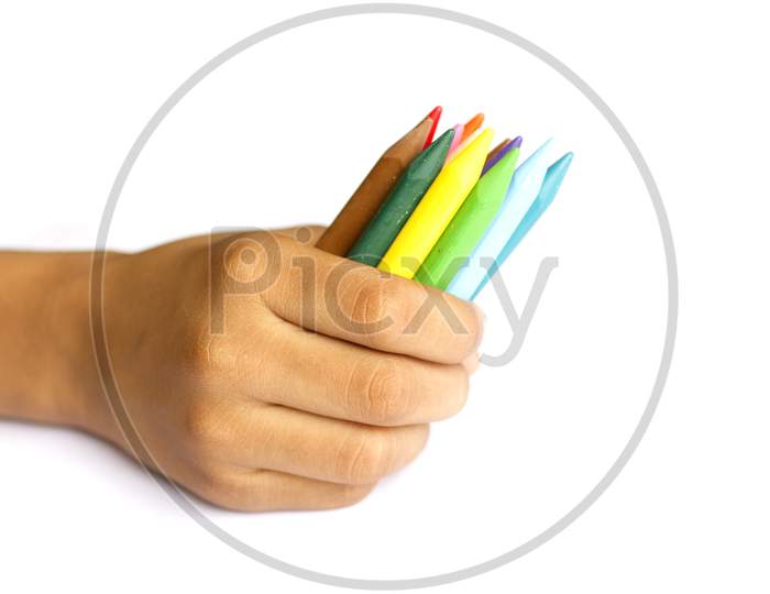 Close up shot of Kid holding Colour Pencils
