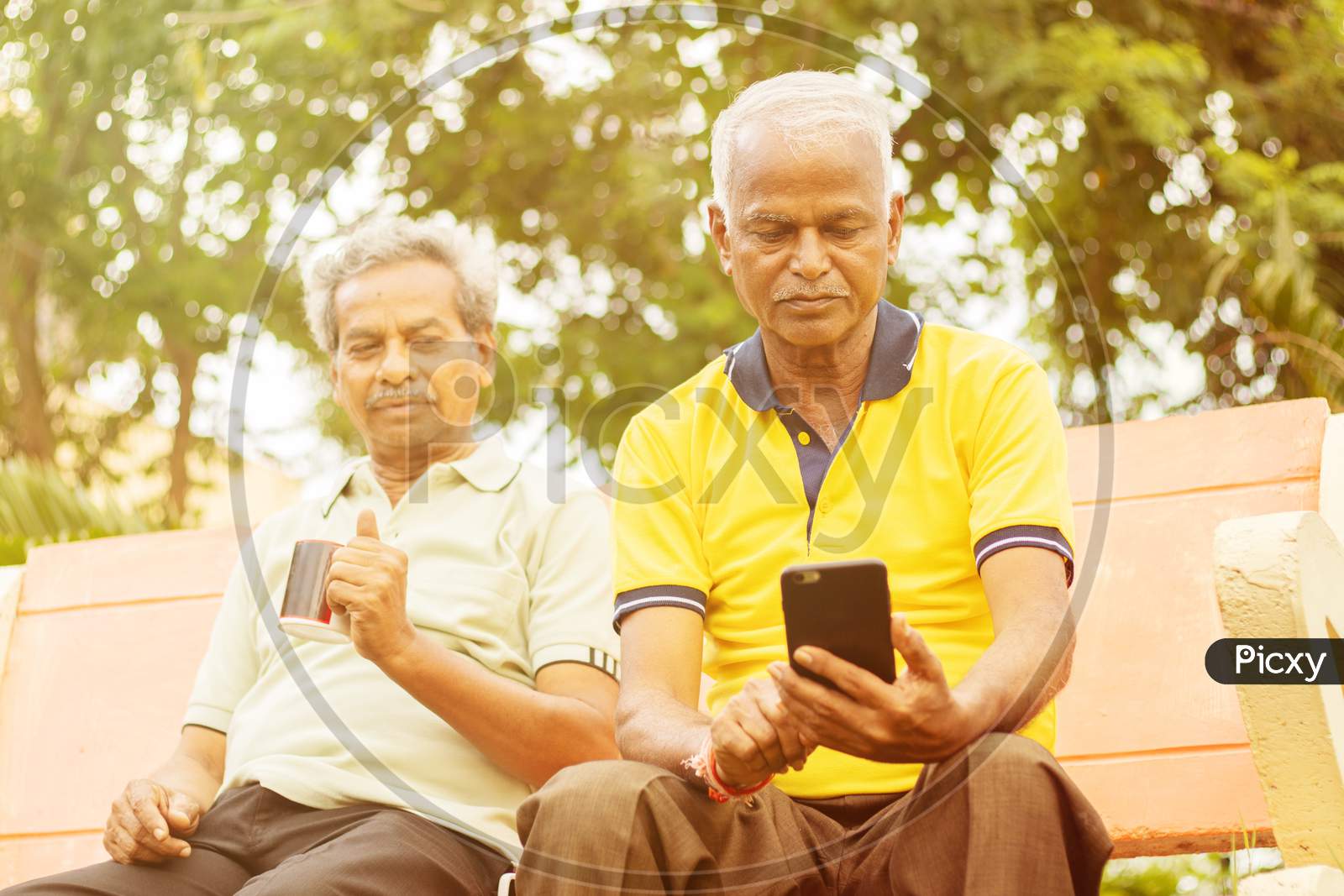 A Couple Of Elderly Man Or Old Men's Using Smartphone or Mobile Phone At Outdoors