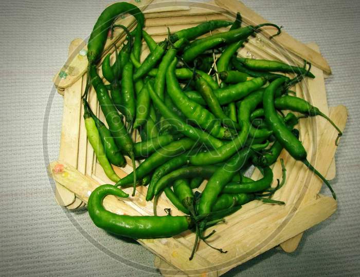 Hari Mirch in tokri , green chillies in wooden bowl