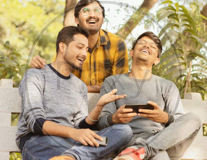 Group Of Friends Laughing Loud By Watching Into Smartphone - Concept Of Young Millennial People Using Technology, Social Media, Internet And Mobile Addiction - Filter Image.