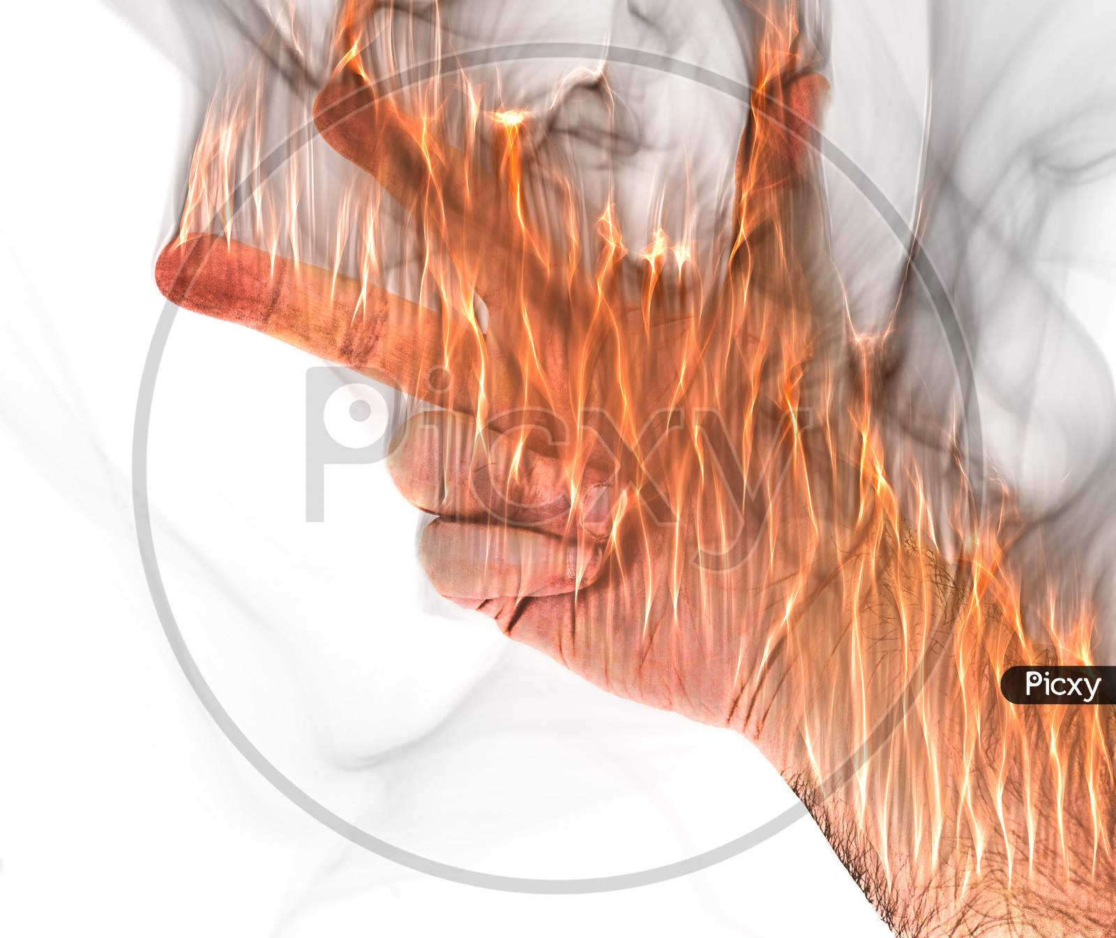 A human hand on fire burning with orange flames and some smoke in front of a white background