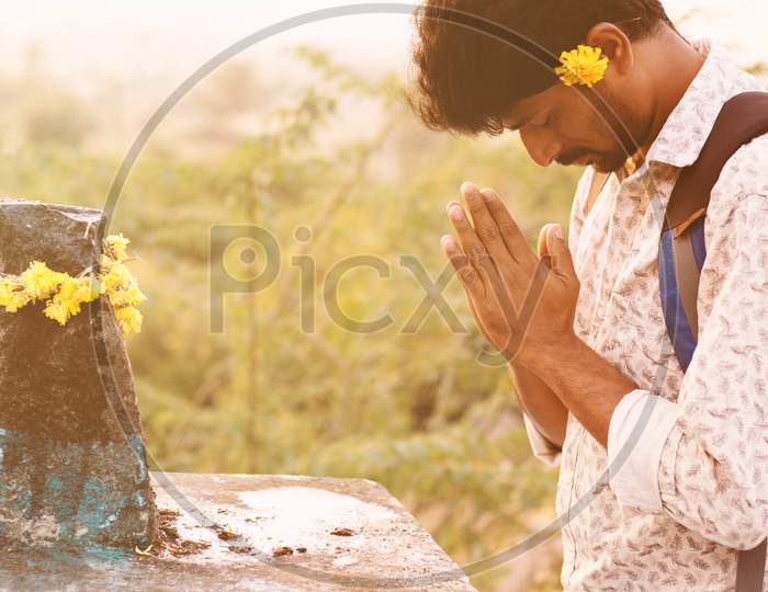 A Young Man praying to God before going to College