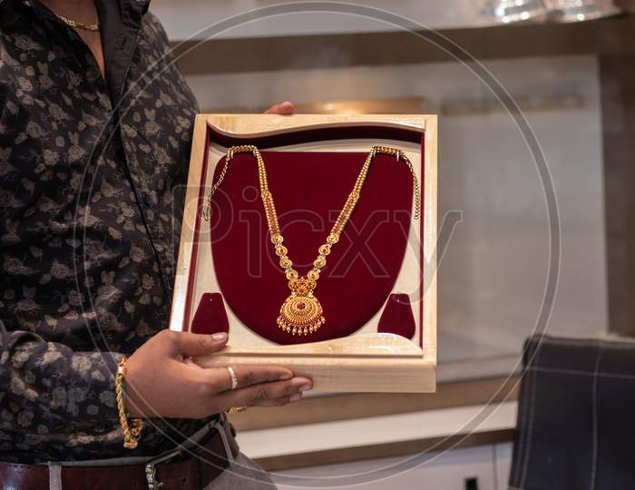 Close Up, Hands Showing Gold Chain At Jewelry Box With Copy Space At Jewellery Store