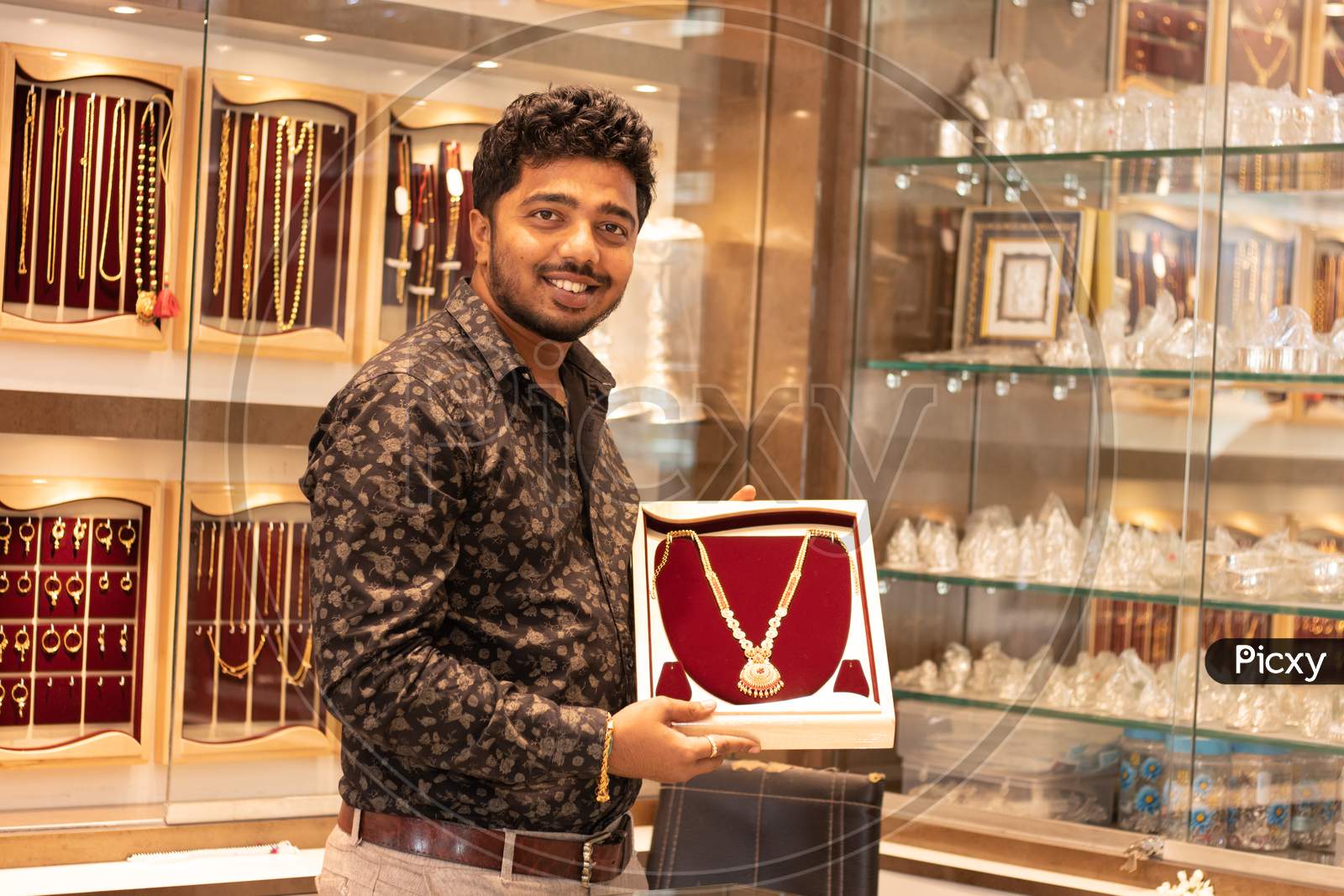 A Person Holding A Gold Chain At Jewelry Box With Copy Space At Jewellery Store