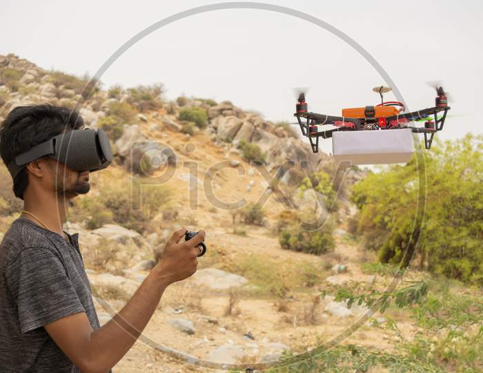 Young Man Trying To Control Drone By Controller By Seeing At Virtual Reality Viewer