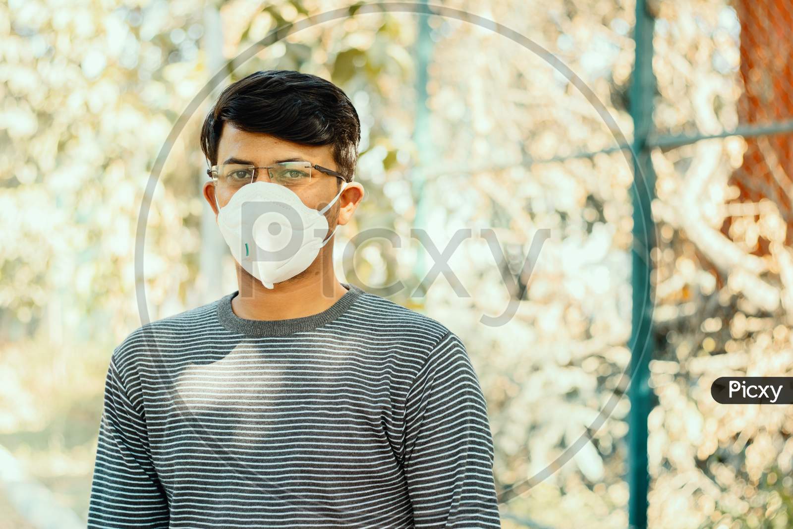 Asian Man Wearing The N95 Medical Face Mask Due To Coronavirus Or Covid-19 Outbreak, Outdoor - Person Protecting From Air Contamination, Coronavirus, Sars Cov 2 Or Viral Infection By Wearing Mask.