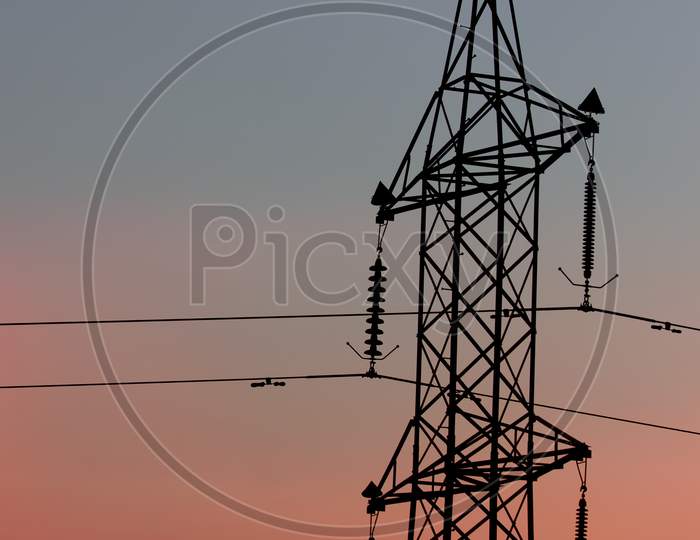 An Electric Tower With Clouds in the Background
